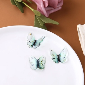 Dettaglio di farfalle in resina verde traslucida con foglia d'oro per creazioni fai-da-te