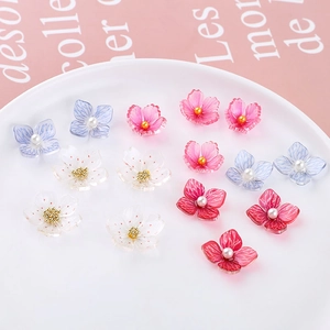 Detailed view of colorful acrylic cherry blossom charms with pearls for DIY jewelry making