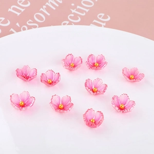 Macro shot of 10 pink acrylic cherry blossom beads with gold centers for DIY jewelry making