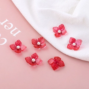 Detailed macro view of red acrylic flower jewelry parts with white pearls and petal texture