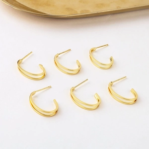 Detalle de pendientes en C bañados en oro de 18K con pernos de plata S925