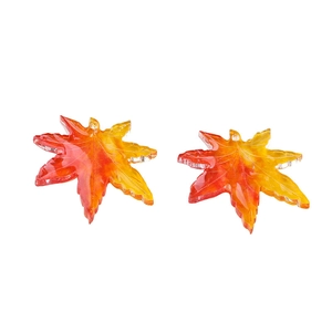 Macro view of gradient red and yellow maple leaf pendants for DIY jewelry making