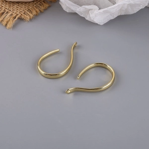 Close-up of golden curved U-shaped earring hooks for DIY jewelry making accessories