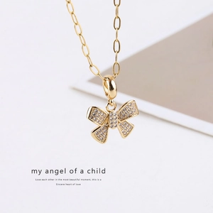 Macro detail of 14K gold plated bow pendant encrusted with shimmering cubic zirconia