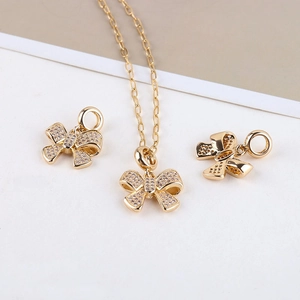 Detailed view of 14K gold plated bow pendants with zircon pave for DIY jewelry making