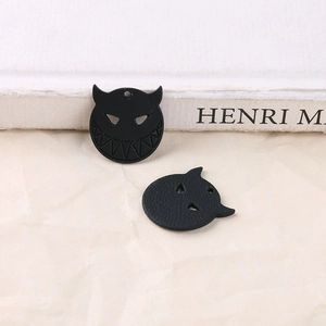 Macro detail of matte black alloy devil face charms for DIY jewelry making and crafts