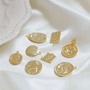 Ciondoli moneta vintage placcati oro 18k con ritratto e rilievo floreale su seta bianca