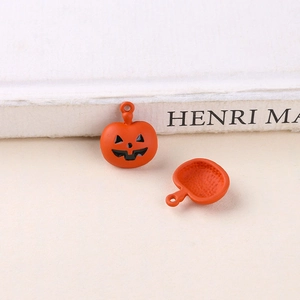 Detail of orange Halloween pumpkin charm with black face and honeycomb textured back