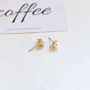 Detailed macro view of baroque pearl stud earrings with gold gear base and DIY loop