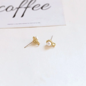 Close-up of baroque pearl earring with golden base on a minimalist artistic card