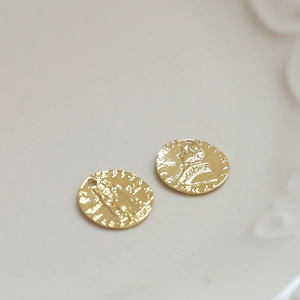 Dettaglio di ciondoli vintage a moneta tonda placcati oro 18k con ritratto a rilievo per gioielli
