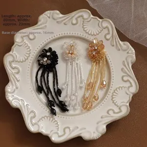 Detailed view of handmade beaded flower tassels in black, clear, and champagne gold