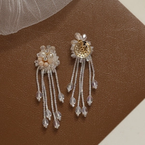 Detailed macro view of crystal flower tassel earrings with beaded petal design