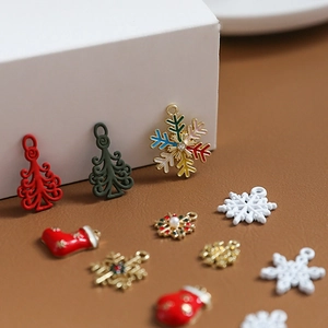 Macro shot of festive enamel Christmas tree, snowflake, and sock jewelry pendant charms