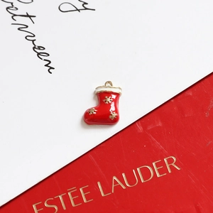 Detailed view of a red Christmas stocking pendant with white trim and gold snowflakes