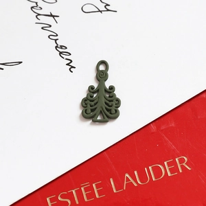 Detail of dark green matte Christmas tree pendant with intricate hollow pattern and ring