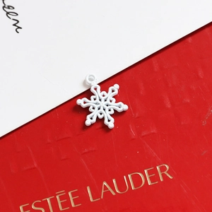 Macro shot of white snowflake alloy pendant with delicate cutout design for DIY jewelry