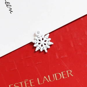 Detail of a white snowflake pendant with a round hanging loop for holiday jewelry DIY