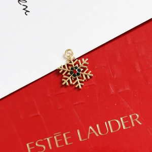 Macro view of gold snowflake charm with red and black crystals for DIY jewelry making