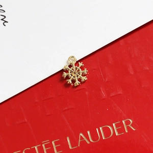 Detailed view of a golden snowflake charm with a hanging loop for DIY jewelry making