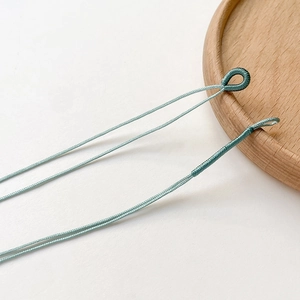 Makroaufnahme der türkis geflochtenen Schnur mit Wickelöse für DIY-Schmuckanhänger