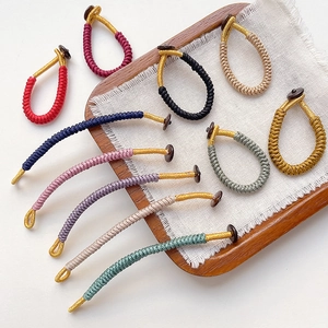 Macro shot of assorted handmade braided rope rings with golden thread and button closures