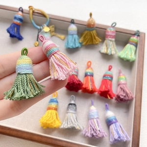 Close-up of colorful woven tassels with metallic gold thread for DIY craft accessories