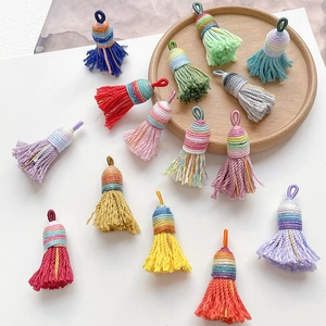 Detail of colorful woven tassel pendants with gold thread and hanging rings for DIY crafts