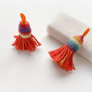 Detail of hand-woven ethnic tassel pendant with gold thread and fluffy cotton fringe