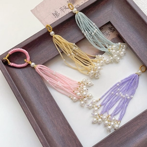 Macro detail of handmade beaded silk tassels with white pearls in multiple pastel colors