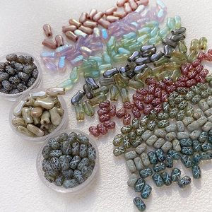 Detailed view of colorful Czech glass beads in bow and fish shapes for DIY jewelry making