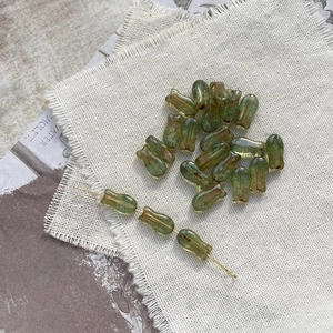 Macro view of vintage green tulip glass beads with golden wire for DIY jewelry making