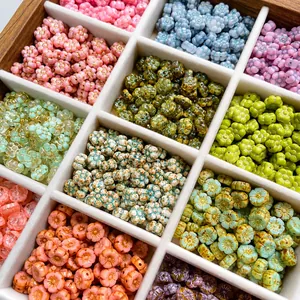 Detailed top view of assorted colorful Czech glass flower beads in a wooden jewelry tray