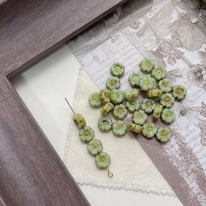 Macro detail of light green flower beads with vintage finish for DIY jewelry crafts