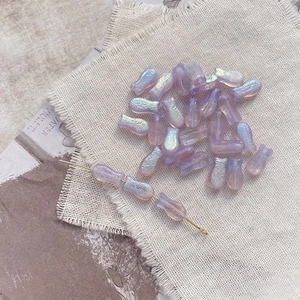 Macro detail of lavender iridescent fish-shaped glass beads for DIY jewelry making
