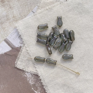 Macro shot of iridescent grey fish-shaped Czech glass beads for DIY jewelry making