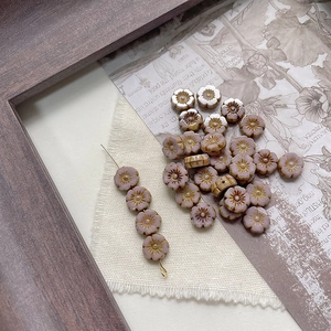 Macro detail of handmade Czech glass flower beads with a vintage pink Picasso finish