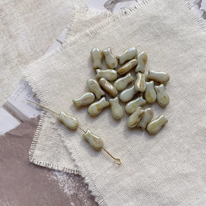 Macro detail of retro fish-shaped glass beads for DIY jewelry with artistic texture