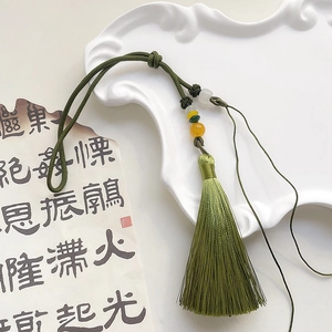 Detail of green handmade ice silk tassel with decorative beads for DIY crafts