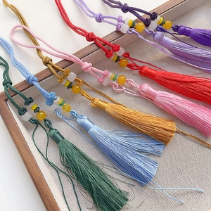 Macro detail of handmade colorful silk tassels with woven knots and decorative beads