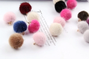 Close-up of colorful faux mink fur pom-poms with metal loops for DIY jewelry making