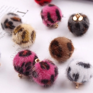 Detail van luipaard faux fur pompons met gouden lussen voor DIY sieraden maken