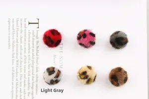 Detail van zes luipaardprint pom-poms van imitatiebont voor DIY-sieraden