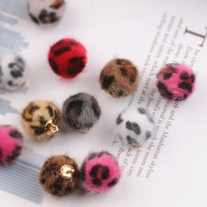 Detailopname van kleurrijke luipaard faux fur ballen met gouden metalen lusjes