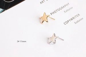 Detail view of 11mm star-shaped gold and silver earrings with a polished metallic finish