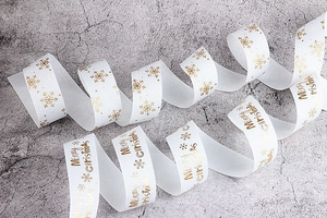 Dettaglio del nastro canneté bianco con testo Merry Christmas dorato e fiocchi