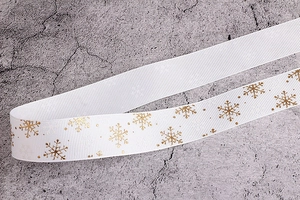 Dettaglio di nastro grosgrain bianco con fiocchi di neve dorati per decorazioni natalizie