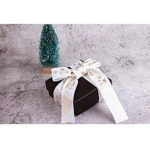 Nastro di Natale bianco con testo Merry Christmas dorato e fiocchi su pacco regalo