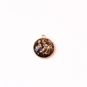 Detail of round alloy pendant with gold foil inlay and twisted metal border for DIY jewelry