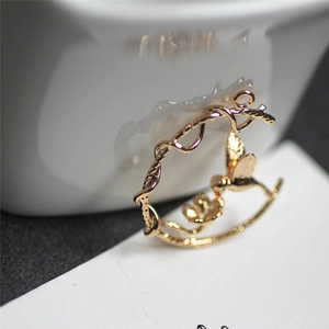 Detalle macro del colgante de pájaro y flor bañado en oro 18K para creación de joyas